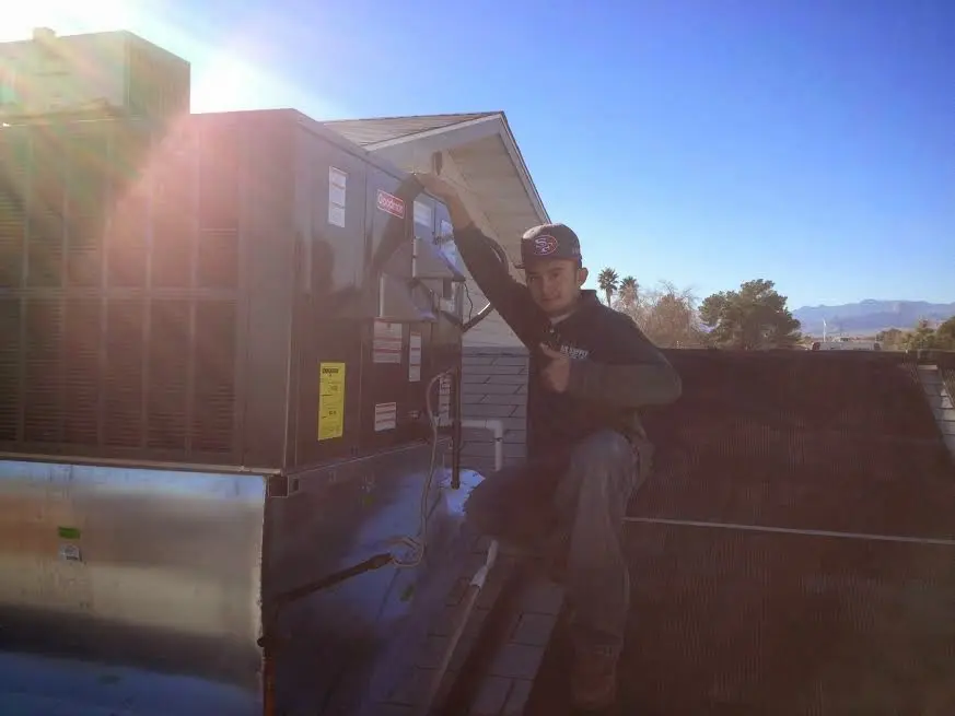 HVAC technician performing AC Tune-Up on a rooftop unit in Norfolk